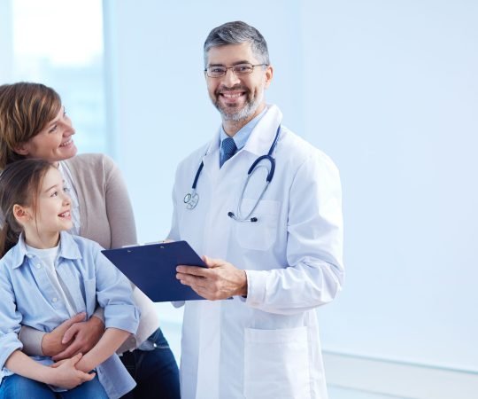 Cute girl and her mother looking at the doctor in hospital